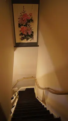 a stairway with a painting of flowers on the wall at B&B La Villa Zarin in Brussels