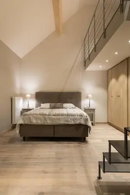 a bedroom with a large bed and two tables at B&B De Windheer in Sint-Martens-Lennik