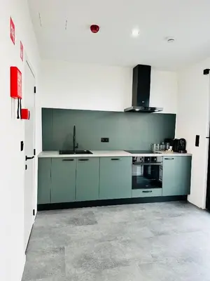 a kitchen with green cabinets and a sink at Hotel Arriate in Lochristi