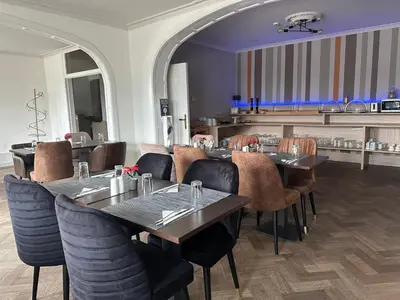 a restaurant with tables and chairs in a room at Hotel Arriate in Lochristi