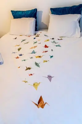 a bed with origami birds flying around it at B&B 1 uit de 100 in Ghent