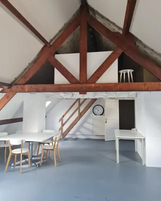 a room with tables and chairs and a clock at B&B 1 uit de 100 in Ghent