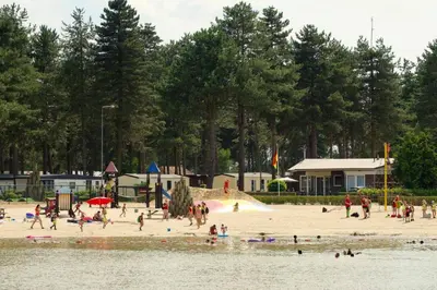a group of people on a beach near the water at Luxe vakantiehuis in het bos in Overbroek