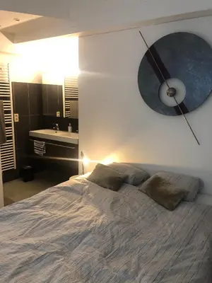 a bedroom with a bed with a clock on the wall at B&B Loft Jamar Gare Du Midi in Brussels