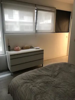 a bedroom with a bed and a dresser with a window at B&B Loft Jamar Gare Du Midi in Brussels