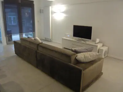 a brown couch in a living room with a television at B&B Loft Jamar Gare Du Midi in Brussels