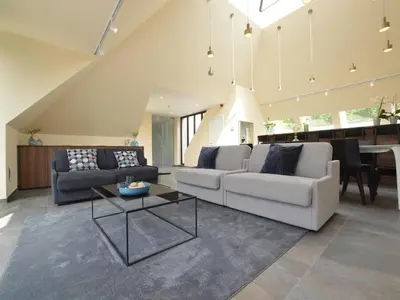 a living room with two couches and a table at Lovely holiday home 'Walleken' with a pond in Eekhout