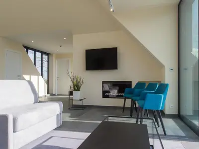 a living room with a white couch and blue chairs at Lovely holiday home 'Walleken' with a pond in Eekhout