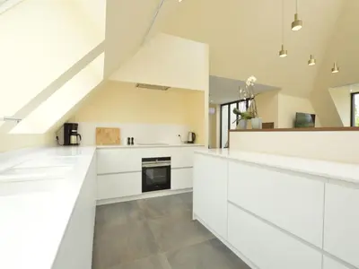 a kitchen with white cabinets and a staircase at Lovely holiday home 'Walleken' with a pond in Eekhout