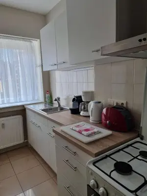 a kitchen with white cabinets and a stove top oven at Aparthotel Résidence Bara Midi in Brussels