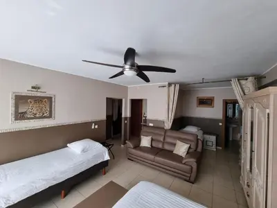 a bedroom with two beds and a ceiling fan at Aparthotel Résidence Bara Midi in Brussels
