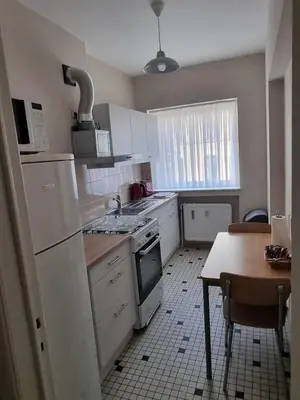 a kitchen with white appliances and a table with a tableablish at Aparthotel Résidence Bara Midi in Brussels