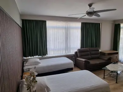 a hotel room with two beds and a couch at Aparthotel Résidence Bara Midi in Brussels