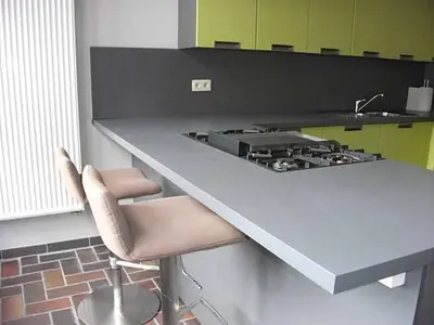 a kitchen with a counter with a stove and two chairs at Geldmunt Apartment in Ghent