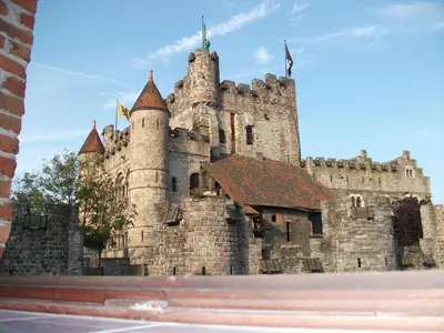 a large castle with a flag on top of it at Geldmunt Apartment in Ghent
