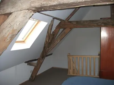 a bedroom with wooden beams and a window at Geldmunt Apartment in Ghent
