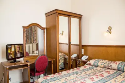 a hotel room with a bed and a mirror at Hotel Continental Gare du Midi in Brussels
