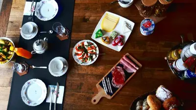 a wooden table topped with plates and bowls of food at Domus Portus in Dendermonde