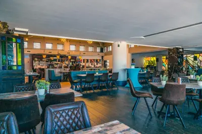 a restaurant with tables and chairs and a bar at EuroParcs Zilverstrand in Mol