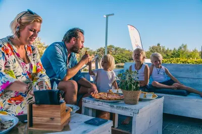 a group of people sitting around a table eating food at EuroParcs Zilverstrand in Mol