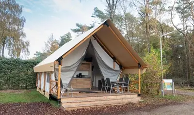 a tent with a table and chairs in a field at EuroParcs Zilverstrand in Mol