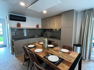 a kitchen and dining room with a table and chairs at EuroParcs Zilverstrand in Mol