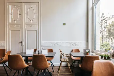 a restaurant with two tables and chairs and a window at Charlie's Bed & Breakfast in Antwerp