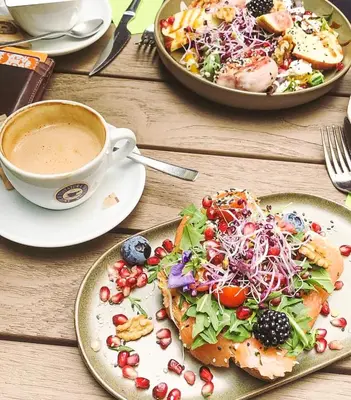a table with two plates of food and a cup of coffee at Charlie's Bed & Breakfast in Antwerp
