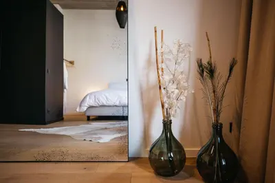 two black vases with flowers in a room at Charlie's Bed & Breakfast in Antwerp