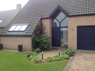a brick house with a blue garage door at didi logement in Westerlo