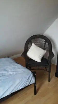 a bedroom with a wicker chair with a pillow on it at didi logement in Westerlo