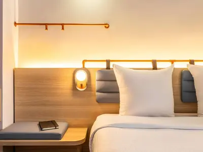 a bedroom with a bed and a desk with a book on it at Hotel Siru Brussels in Brussels