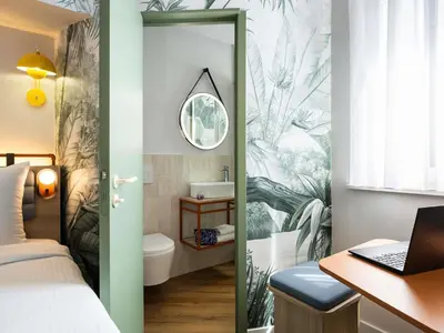 a bedroom with a bed and a desk with a laptop at Hotel Siru Brussels in Brussels