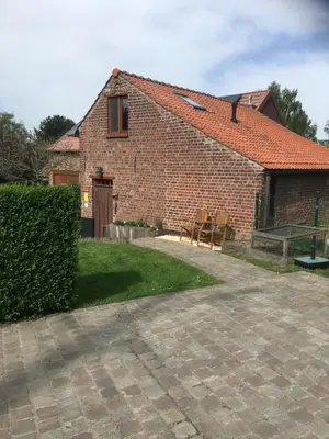 a brick house with some chairs and a patio at 't Huizeke in Asse