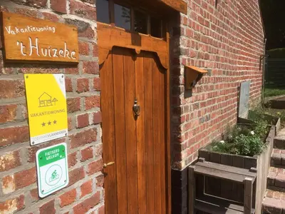 a wooden door on the side of a brick building at 't Huizeke in Asse