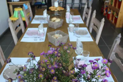 a long wooden table with flowers on it at Saffels Nest in Lochristi
