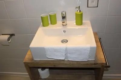 a bathroom sink with two green cups on it at Saffels Nest in Lochristi