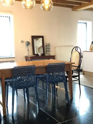 a dining room with a wooden table and chairs at Constantinus in Herzele