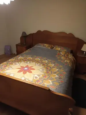 a bed with a colorful blanket on top of it at The best known village of Belgium in Puurs