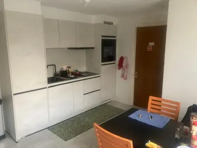 a kitchen with a table and chairs and a kitchen with white cabinets at The best known village of Belgium in Puurs