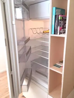 an empty refrigerator with its door open with books at PM87- Modern stylish home in Antwerp