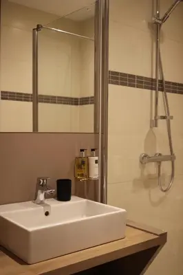 a bathroom with a white sink and a shower at B&B Dotter 17 in Erpe-Mere