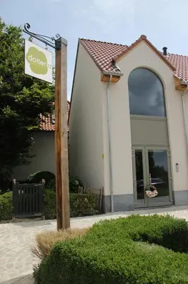 a sign on a pole in front of a building at B&B Dotter 17 in Erpe-Mere