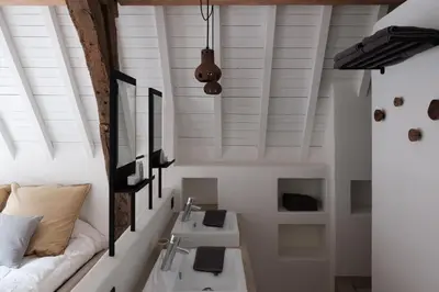 a bathroom with white walls and a sink and a couch at Boutique Holiday Home ZaligInAntwerpen 77 in Antwerp