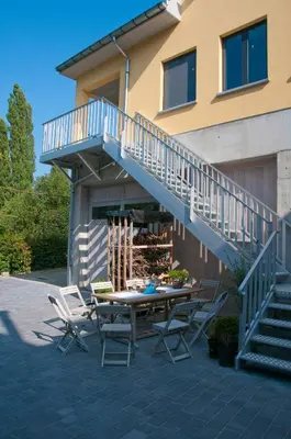 a patio with a table and chairs and a staircase at Hotel Gasthof Kapelhof in Erpe-Mere