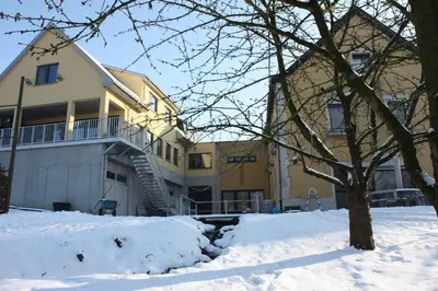 a yellow house with snow in front of it at Hotel Gasthof Kapelhof in Erpe-Mere