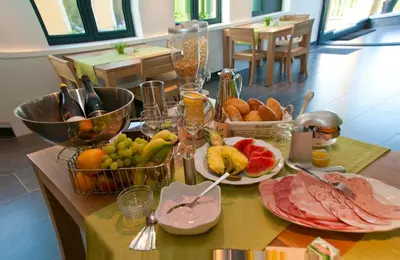 a table topped with plates of food and fruit at Hotel Gasthof Kapelhof in Erpe-Mere