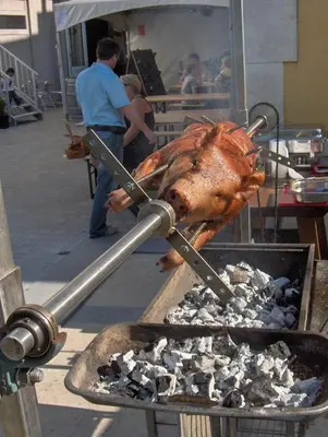 a turkey is being cooked on a grill at Hotel Gasthof Kapelhof in Erpe-Mere