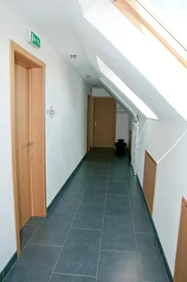 an attic hallway with a staircase with an attic at Hotel Gasthof Kapelhof in Erpe-Mere