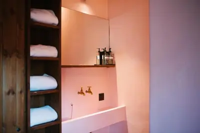 a bathroom with a shelf with towels on it at Friday Gent, Exclusive Charming Guesthouse in Ghent